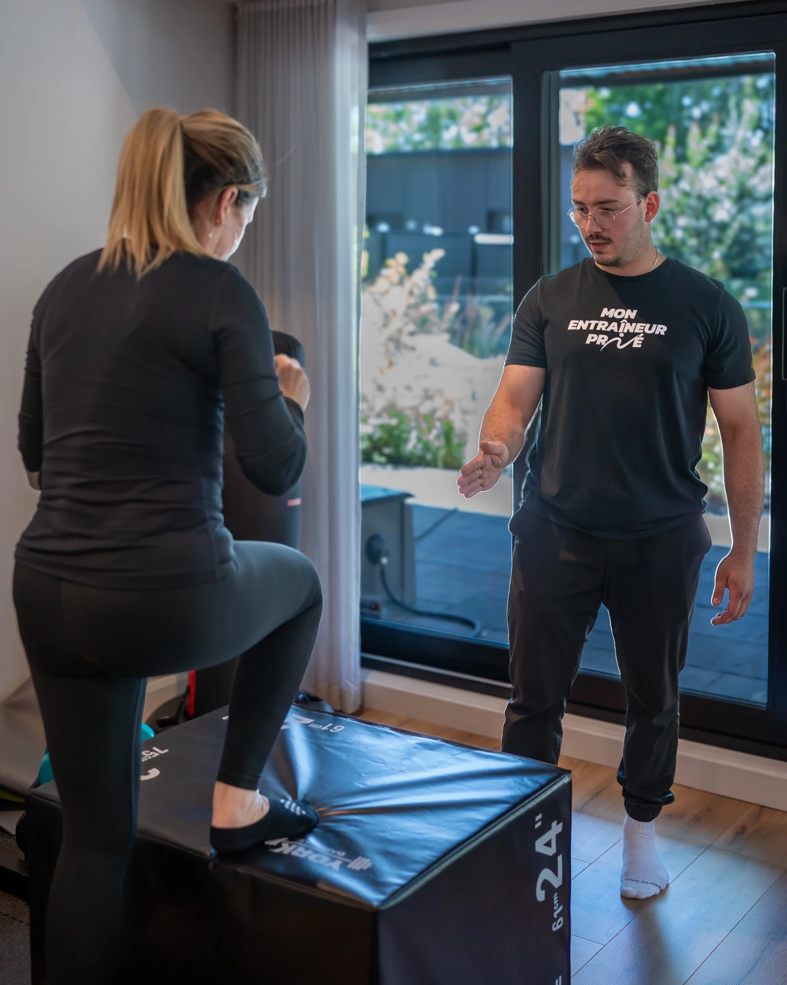 Kinésiologue ajustant la posture d'une cliente — suivi personnalisé